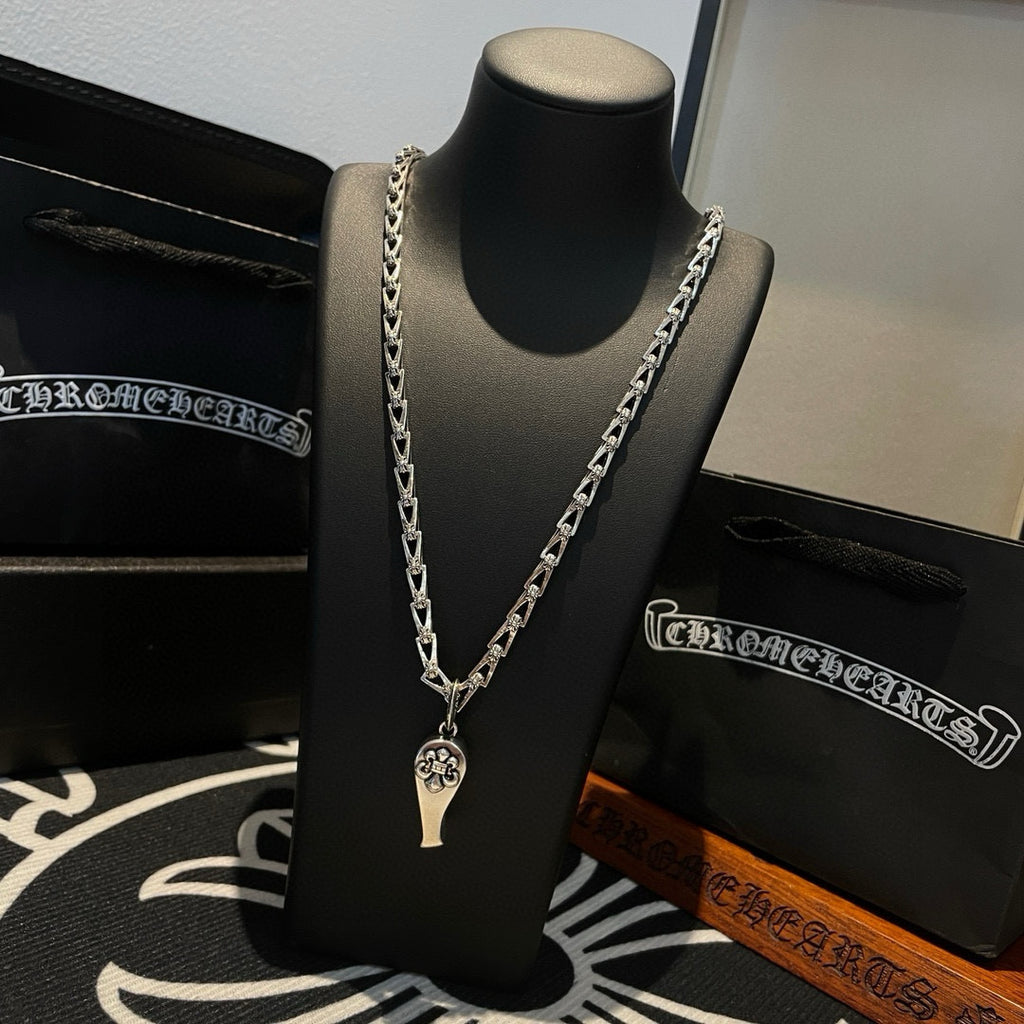 Silver-tone chain necklace with charm pendant, on black display bust