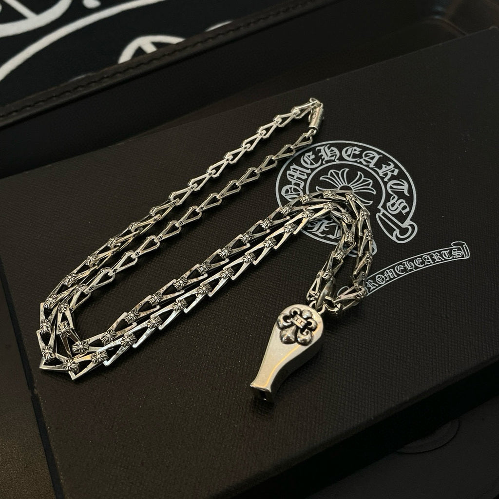 Silver-tone chain necklace set with charm pendants, on black case