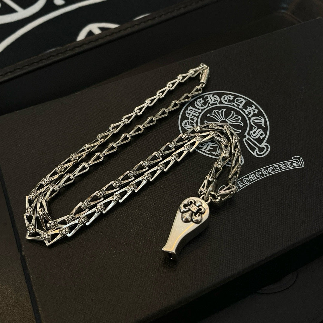 Silver-tone chain necklace set with charm pendants, on black case
