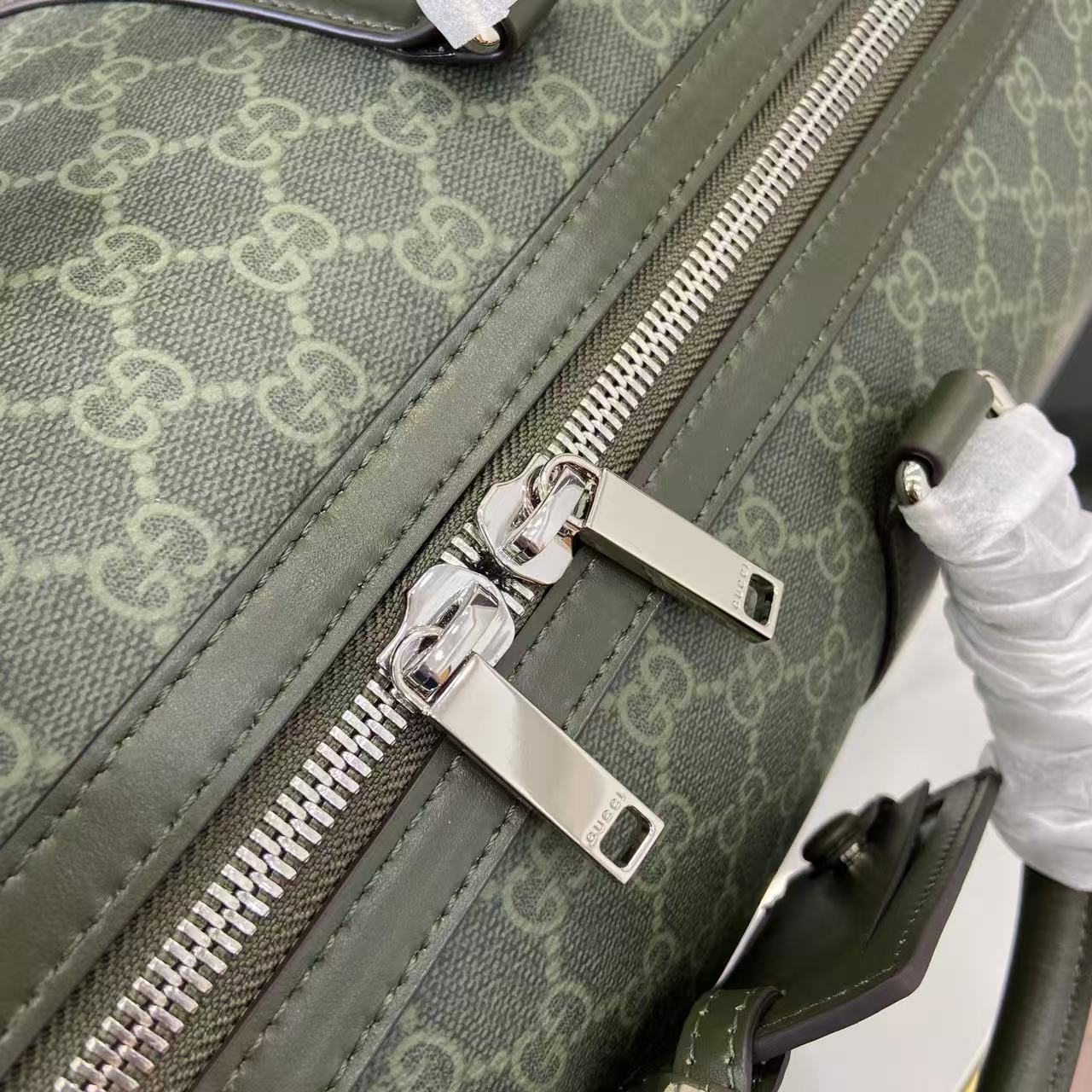 Gucci bag zipper and strap hardware close-up on dark green GG canvas