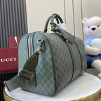 Gucci duffel bag side view in dark green GG canvas with zip pocket and crossbody strap