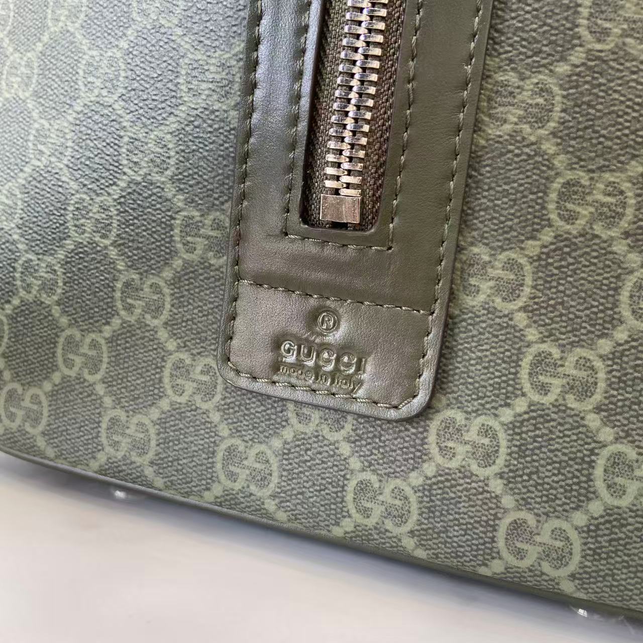 Gucci bag strap section with zipper pull and embossed Gucci logo, gray-green canvas