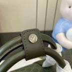 Gucci bag strap end with round silver logo snap hardware on dark green leather
