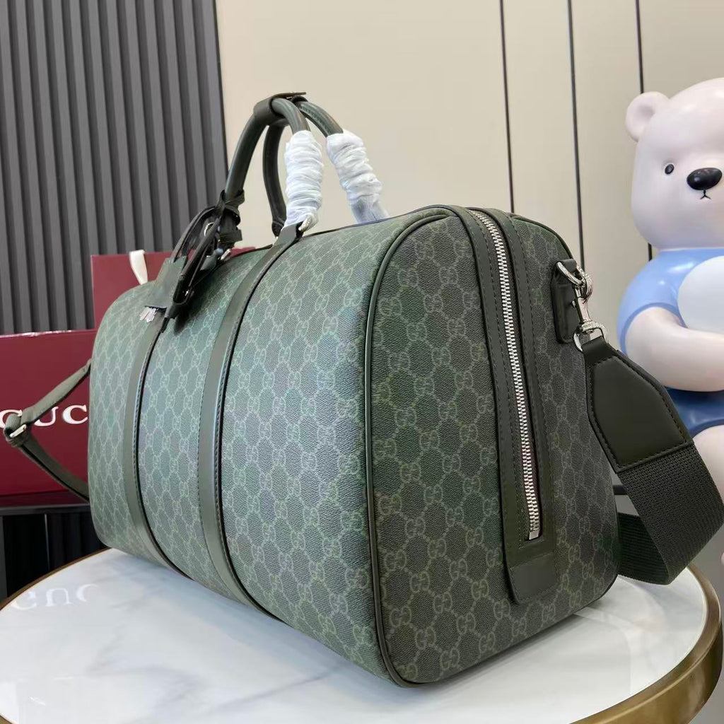Gucci duffel bag angled view in dark green GG canvas with top handles and side zipper
