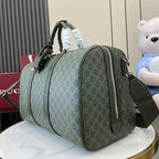 Gucci duffel bag angled view in dark green GG canvas with top handles and side zipper