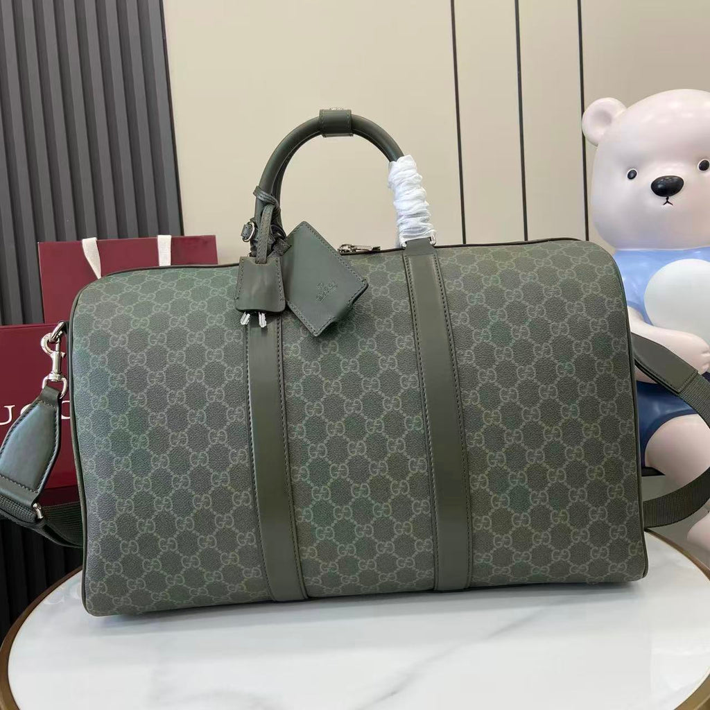 Gucci duffel bag in dark green GG canvas with top handles and front buckle detail