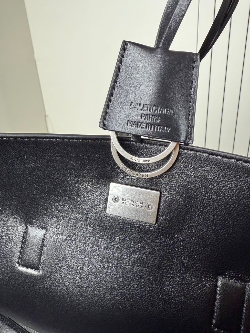 Balenciaga leather bag charm and key ring on black tote with silver plaque