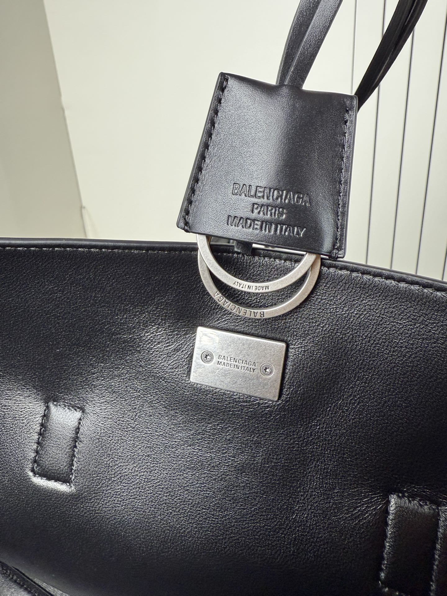 Balenciaga leather bag charm and key ring on black tote with silver plaque