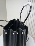 Black leather tote bag open view showing side pockets and silver studs