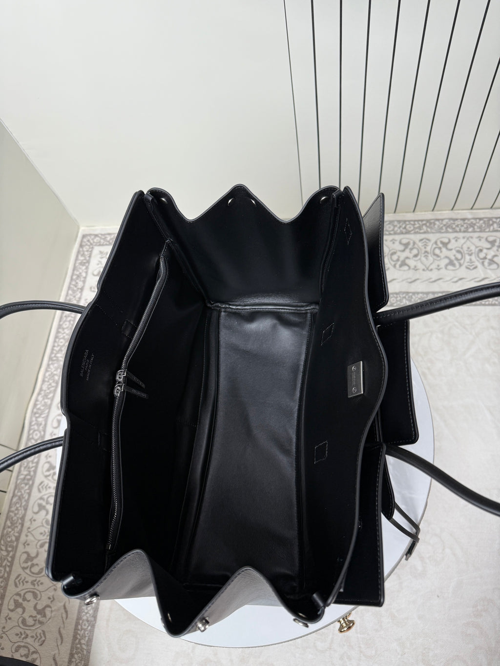 Black leather tote bag open top view with interior lining and label