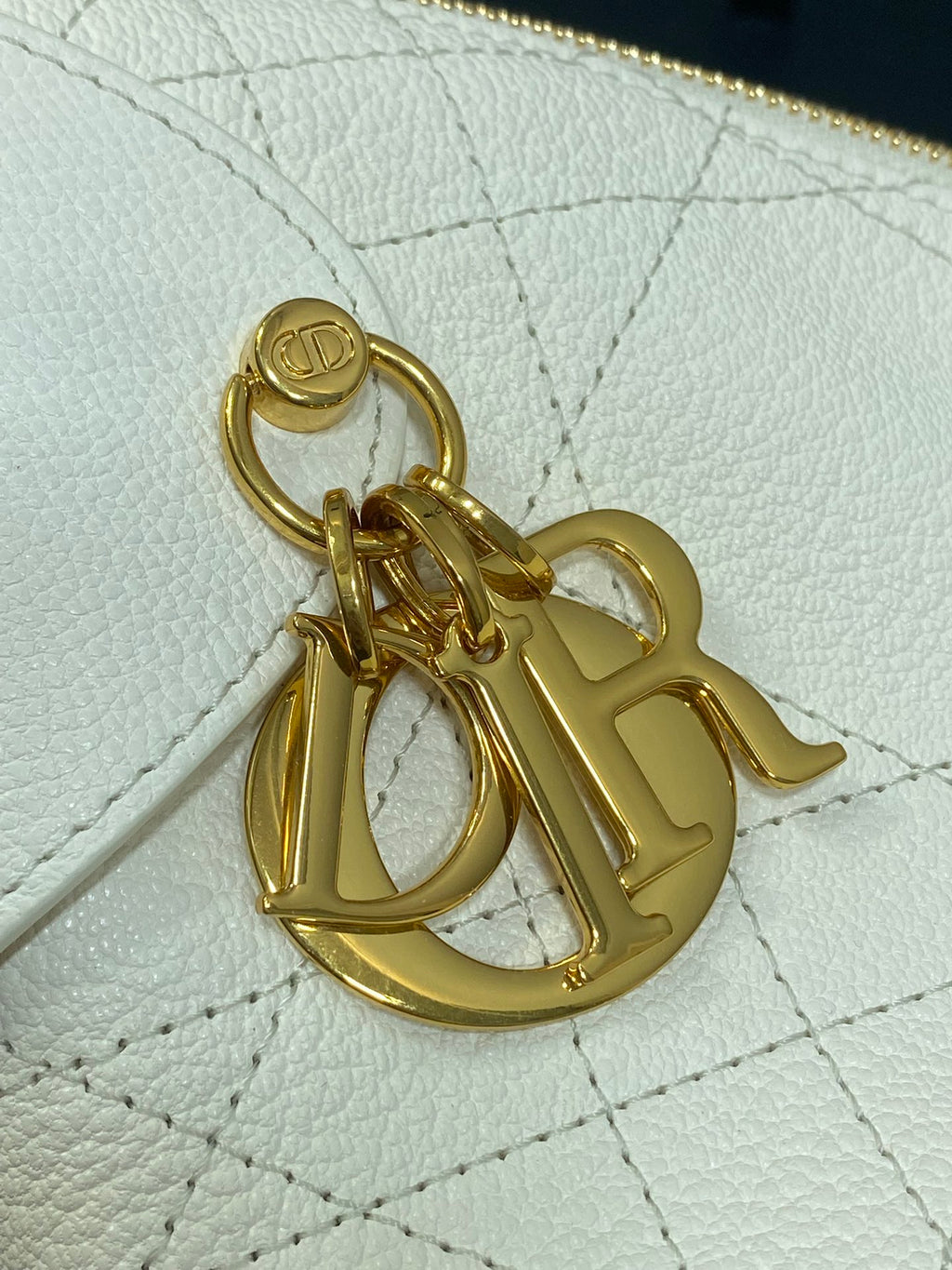 Gold logo charm clasp on white quilted leather bag