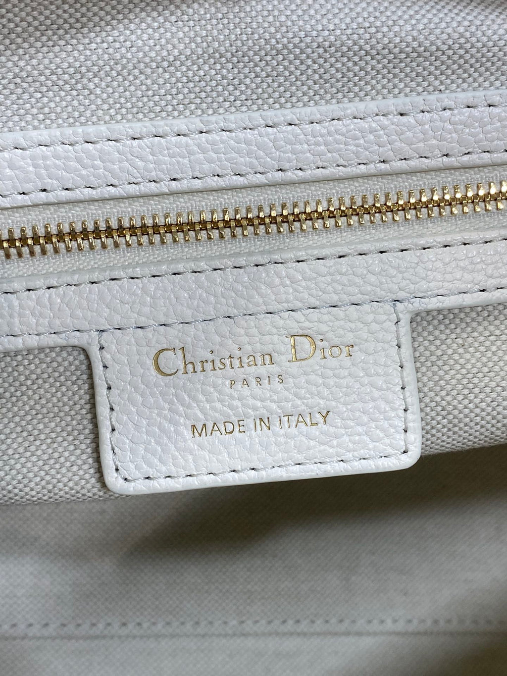 Christian Dior Paris made in Italy label on white leather bag