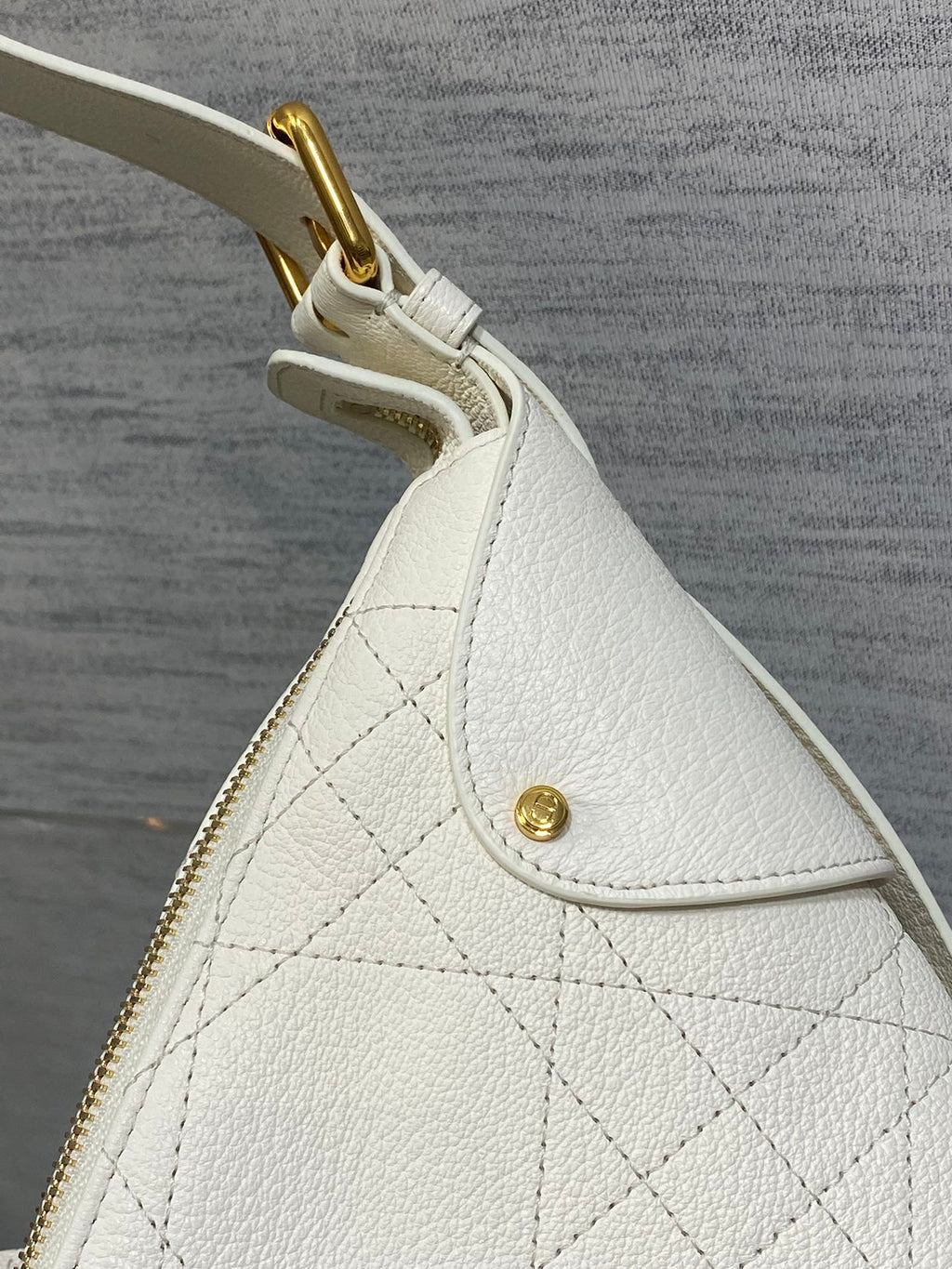 White quilted leather bag side panel with small gold stud