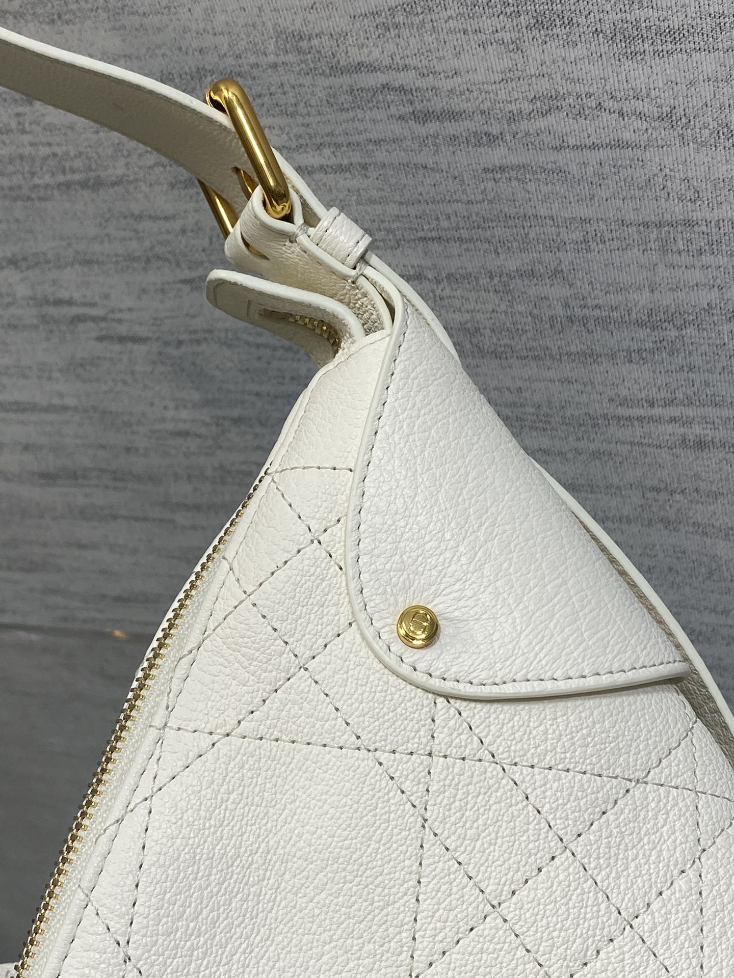 White quilted leather bag side panel with small gold stud