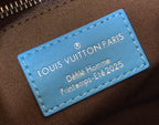 Blue leather logo tag on monogram handbag reading Louis Vuitton Paris Petite Homme