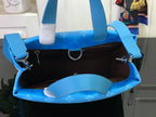 Open monogram handbag interior with blue lining, rings, and top handles