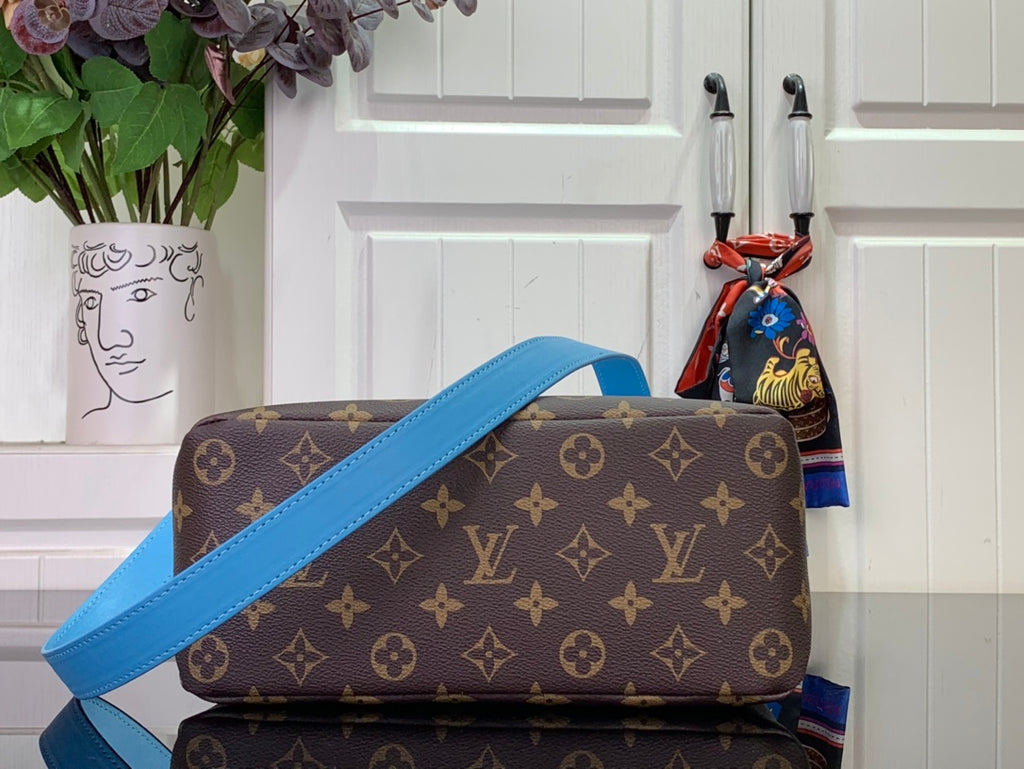 Blue and brown monogram handbag with crossbody strap and top handle, side view