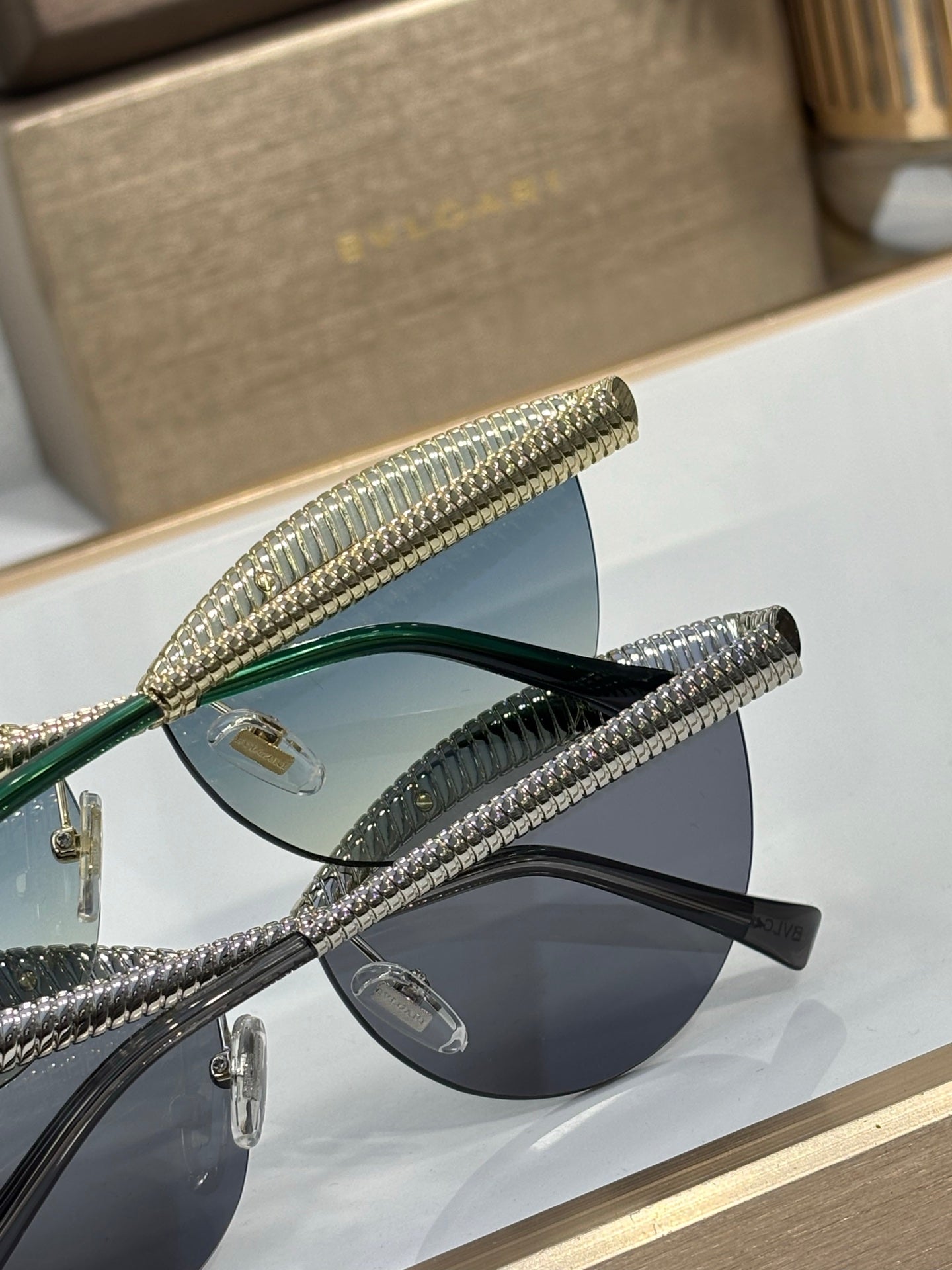 Bvlgari sunglasses close-up: gold metal frame with blue and dark tinted lenses
