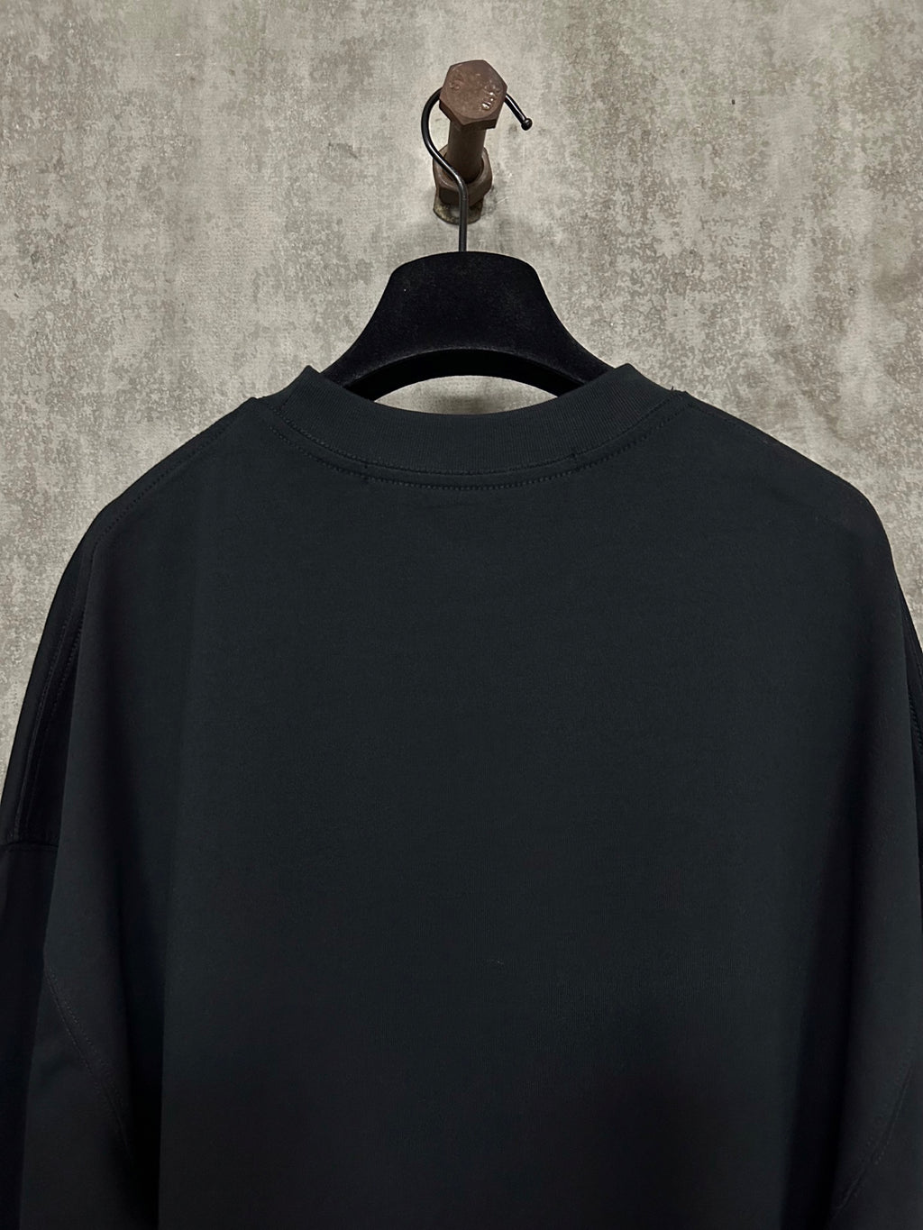 Black long-sleeve crewneck shirt, back view