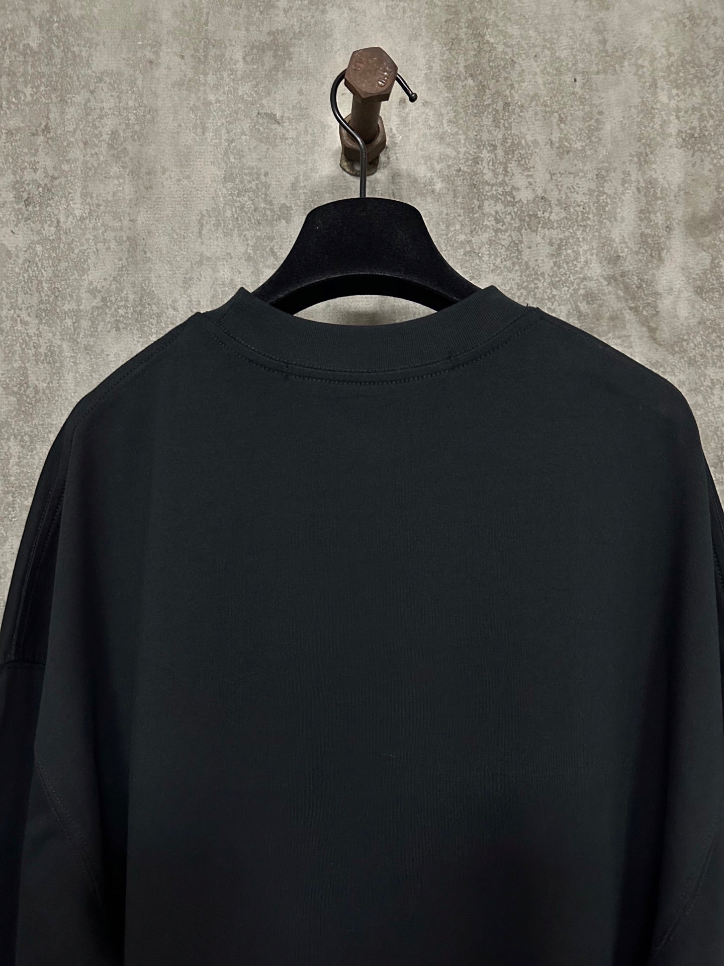 Black long-sleeve crewneck shirt, back view