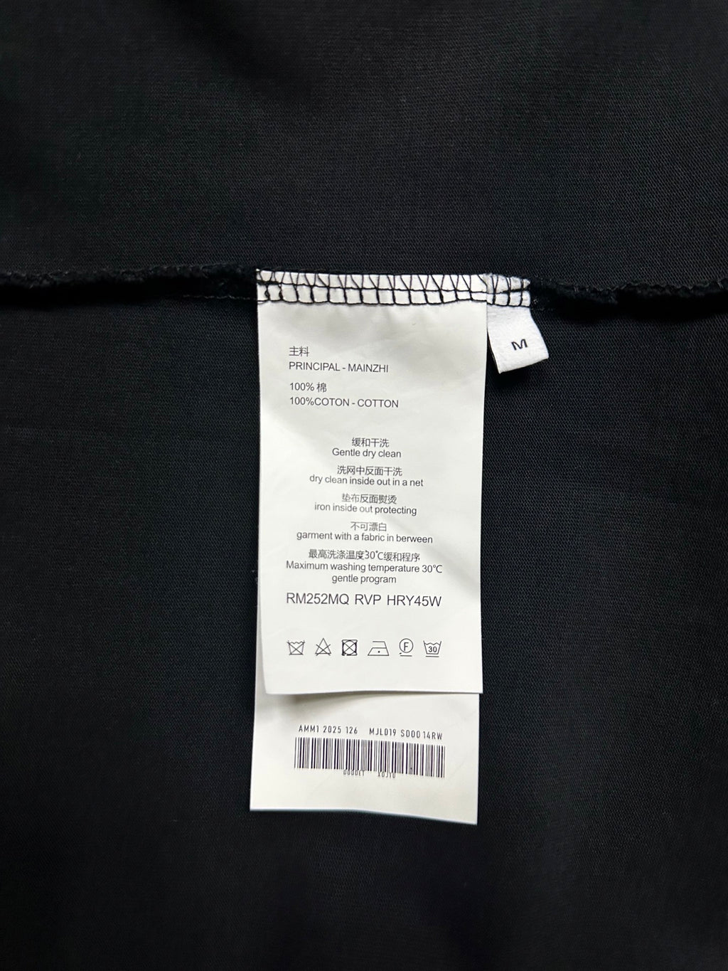 Clothing care label on black long-sleeve shirt, size M