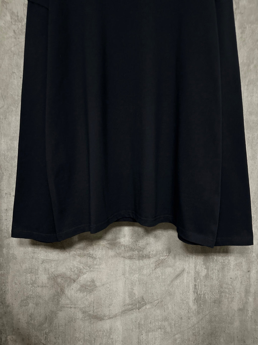 Black long-sleeve crewneck shirt with curved hem and stitched cuffs