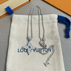Silver layered necklaces and charm bracelet on white drawstring pouch