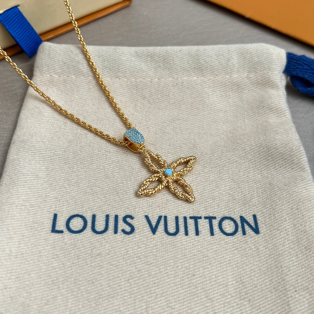 Gold butterfly pendant necklace with blue stones on white pouch