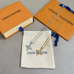 Gold chain necklace set with butterfly charms and blue stones, shown with pouch and boxes