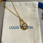 Gold-tone tiger-face pendant necklace with fine chain on white drawstring pouch