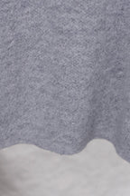 Gray knit sweater fabric texture with scalloped hem edge