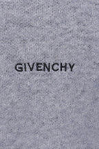 Gray knit sweater close-up with GIVENCHY lettering on front