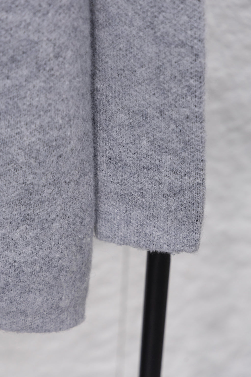 Gray knit sweater side view with straight hem and ribbed cuff