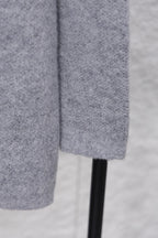 Gray knit sweater side view with straight hem and ribbed cuff