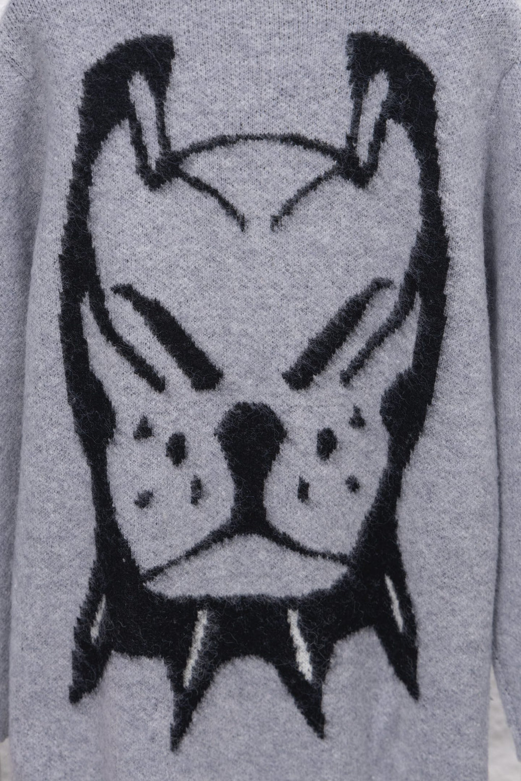 Gray knit sweater close-up of black cartoon animal face graphic