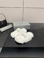 White faux fur slide sandals with silver bow-like logo charm detail