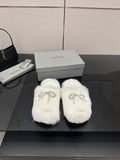 White faux fur slide sandals with silver logo charm detail