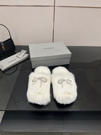 White faux fur slide sandals with silver logo charm detail