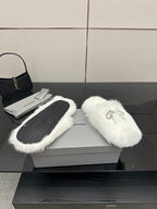 White faux fur slip-on sandals with silver logo charm on top