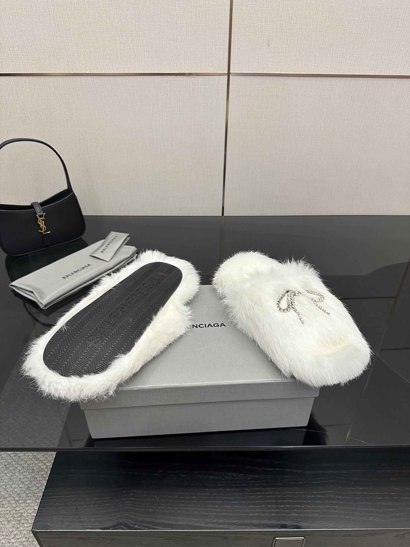 White faux fur slip-on sandals with silver logo charm on top