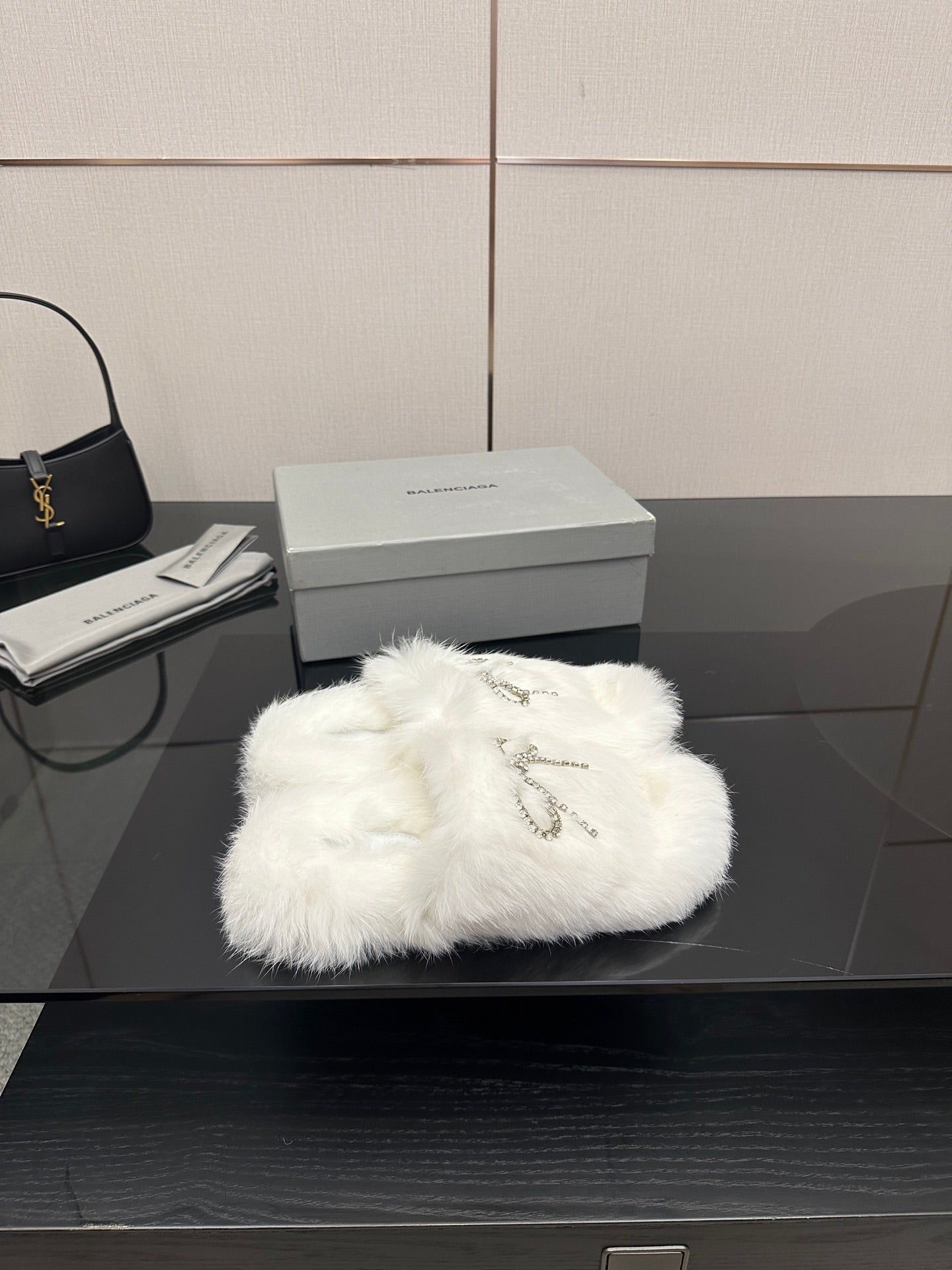 White faux fur slide sandals with silver logo charm detail