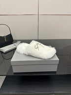 White faux fur slide sandals with silver logo charm on strap