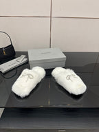 White faux fur slide sandals with silver logo charm on top