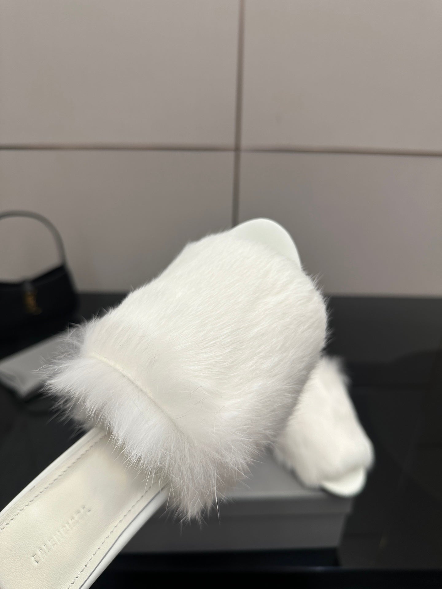 White faux-fur slide sandal close-up, open toe and curved upper