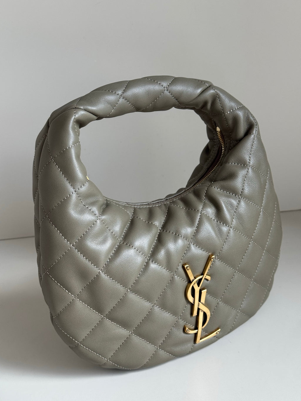 Quilted hobo bag in metallic gray with gold YSL logo and open top view