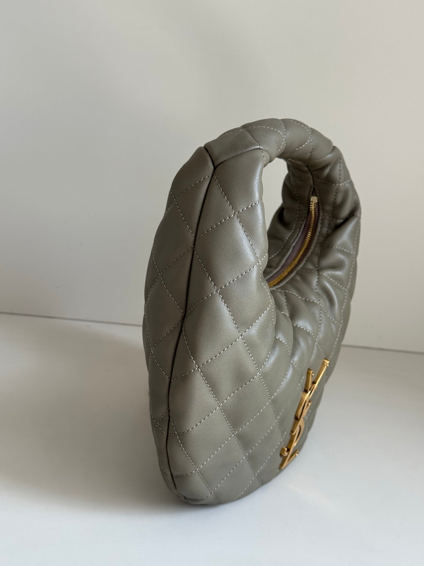Quilted hobo bag in metallic gray with gold zipper and top loop handle view