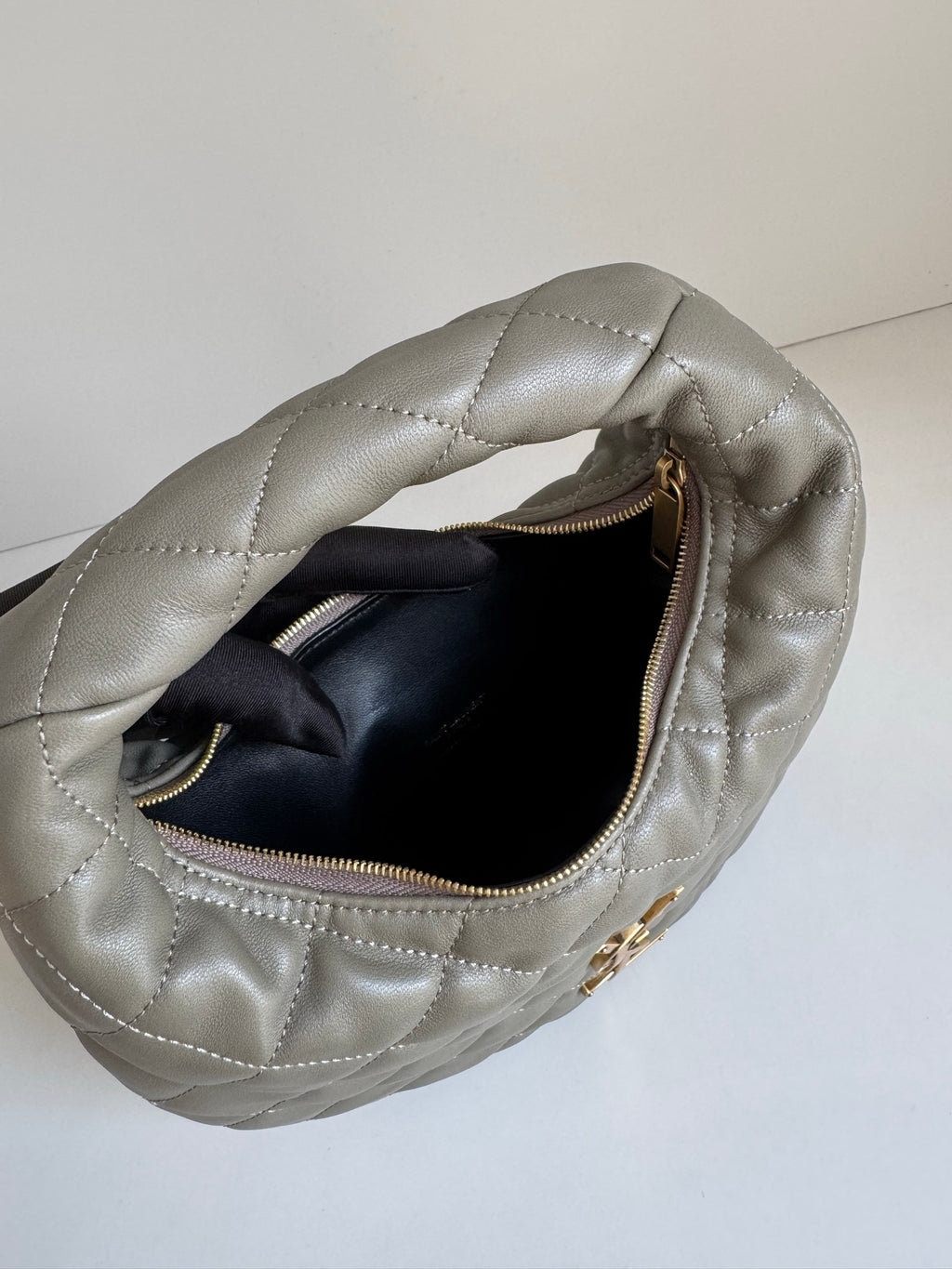 Quilted hobo bag in metallic gray with open top and black interior lining