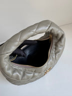 Quilted hobo bag in metallic gray with open top and black interior lining