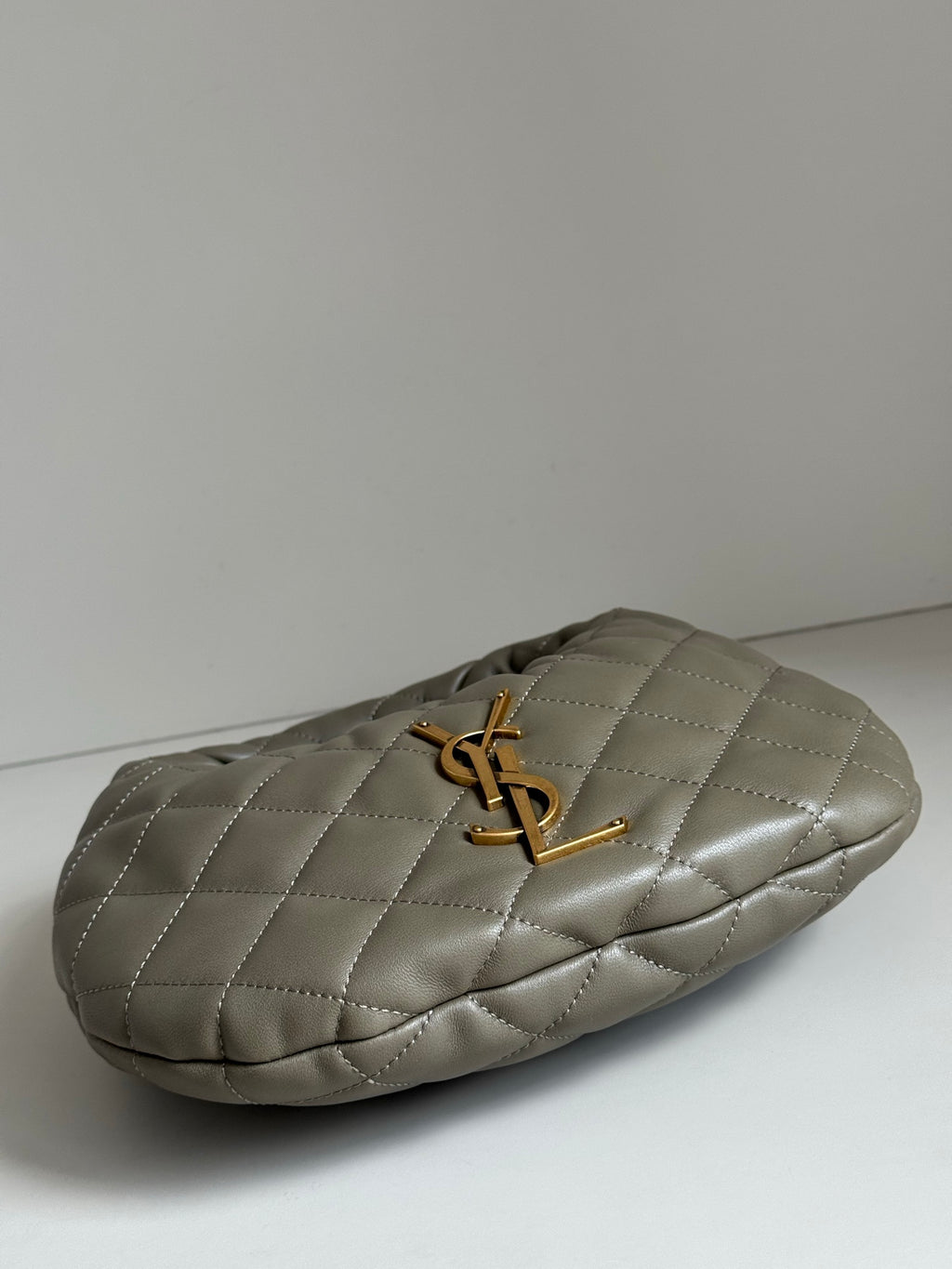 Quilted hobo bag in metallic gray with gold YSL logo, side profile