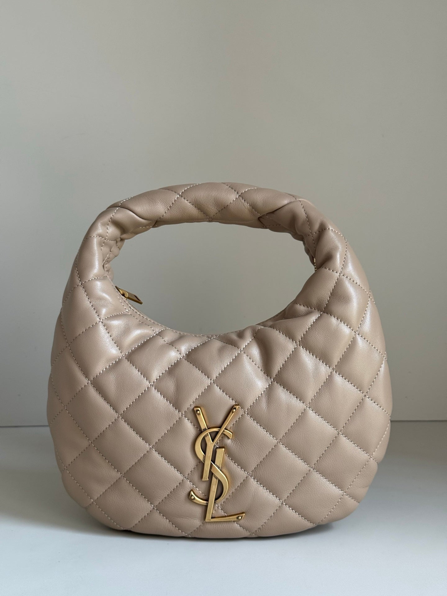 YSL quilted hobo bag in light beige with gold YSL logo on the front
